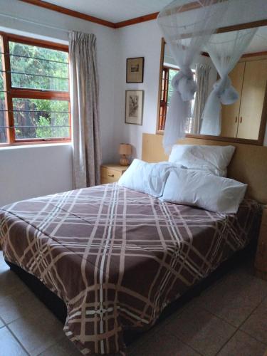 a bedroom with a large bed with a canopy at Bush Beach Safari Accommodation in Jeffreys Bay