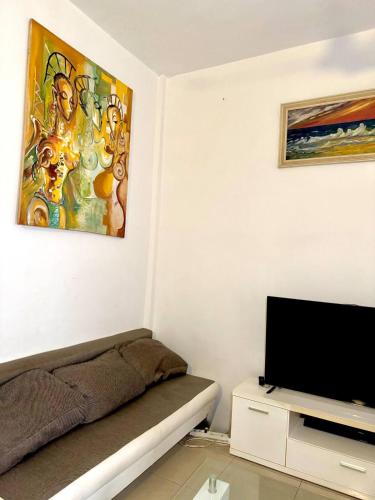 a living room with a couch and a flat screen tv at Cozy Private Apartment For 2 in Cotonou