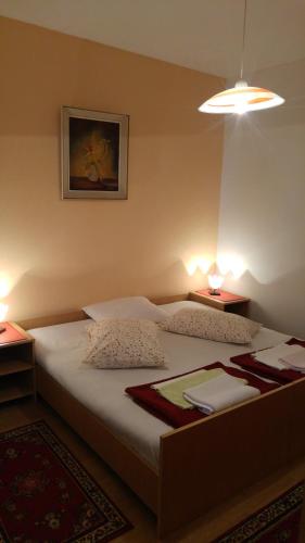a bedroom with a bed with two tables and two lamps at Apartment Maskaric in Cavtat