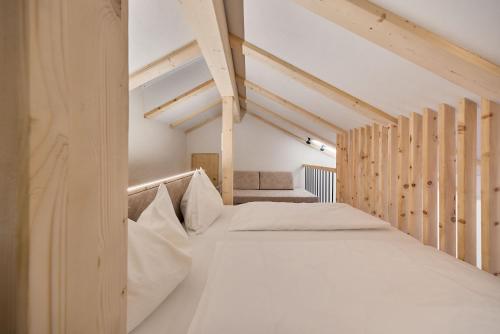 an attic bedroom with two beds in a room at Hotel Schmuckhof in Chiusa