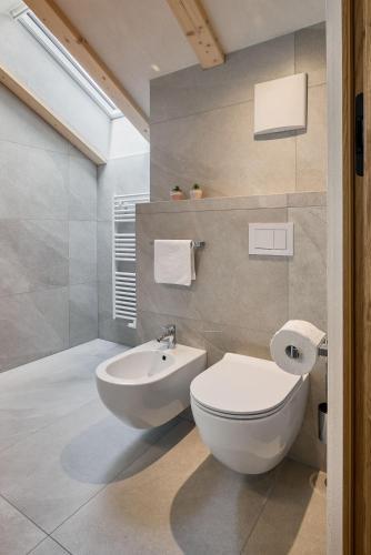 a bathroom with a white toilet and a sink at Hotel Schmuckhof in Chiusa