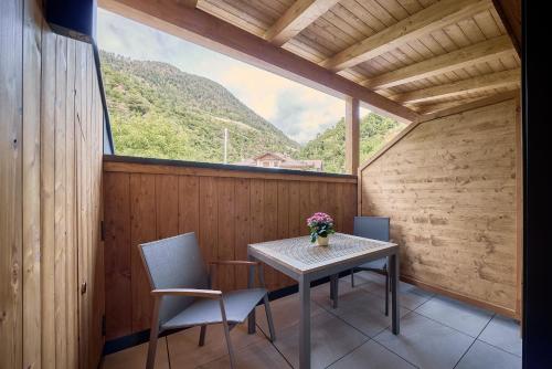 a table and chairs in a room with a large window at Hotel Schmuckhof in Chiusa