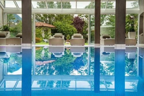 a swimming pool with chairs and the water in a house at FAYN garden retreat hotel in Lagundo