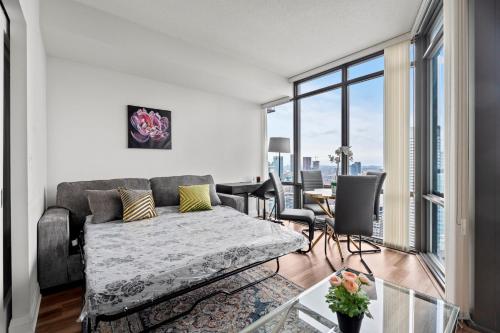 ein Wohnzimmer mit Couch und großem Fenster in der Unterkunft Attractive 1 Bedroom High Floor with Skyline View in Toronto