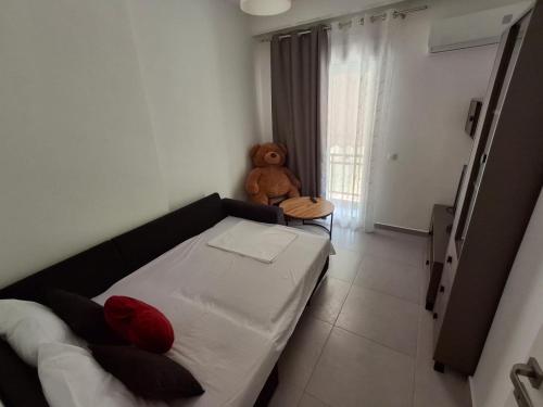 a small room with a couch and a teddy bear at IRIS Apartment in Loutraki