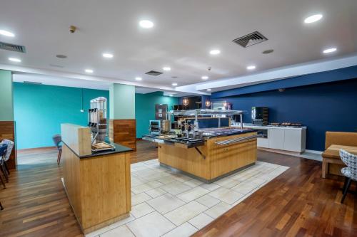 a large room with blue walls and a kitchen at Travelodge Murcia in Murcia