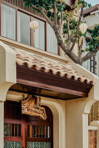 a building with a sign above a door at Hoian Tranquil Beach Villa in An Bang