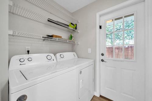 - une buanderie blanche avec lave-linge et sèche-linge dans l'établissement Milo's Beach Bungalow, à Santa Rosa Beach
