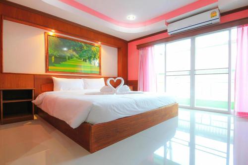 a bedroom with a bed with a heart on it at Hiso Place Hotel 