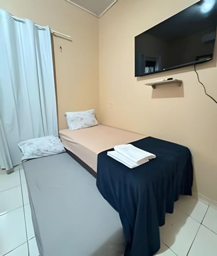 a small room with a bed and a tv at Casa Jardim jabuticabas na fronteira in Brasiléia