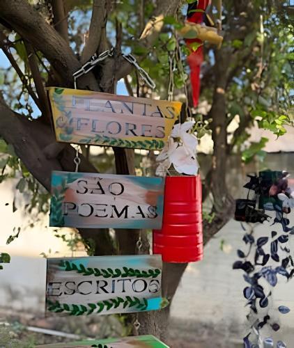 a tree with signs attached to a tree at Casa Jardim jabuticabas na fronteira in Brasiléia