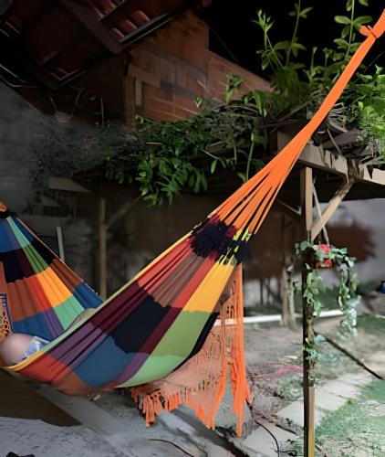 a colorful hammock sitting in front of a house at Casa Jardim jabuticabas na fronteira in Brasiléia