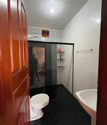 a bathroom with a toilet and a sink at Casa Jardim jabuticabas na fronteira in Brasiléia