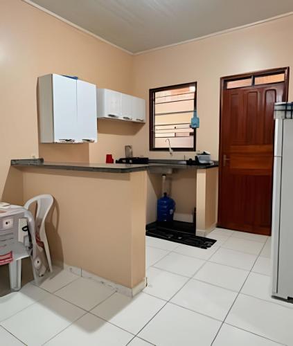 a kitchen with a counter with a sink and a door at Casa Jardim jabuticabas na fronteira in Brasiléia