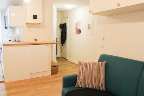 a living room with a blue couch and a kitchen at bright studio with balcony quiet location in Paris
