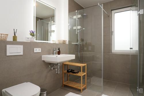 a bathroom with a sink and a shower and a toilet at Wohnkultur - Ferienhaus für 10 auf 140qm mit Garten in Wiesloch