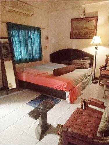 a bedroom with a bed and a window and a chair at Best Place Have Air Conditioner in Bangkok