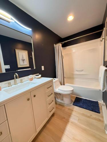 a bathroom with a sink and a toilet and a tub at Seaberry Hideaway, A Modern 2BR Apt 3miles to Bethany Beach in Ocean View