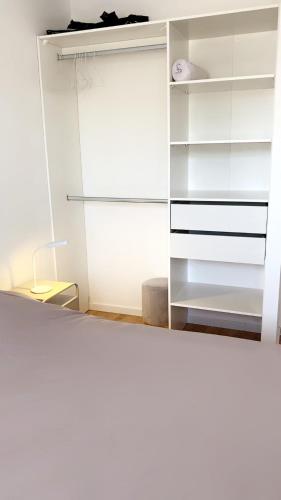 a closet with white cabinets and a mirror at Jolie maison, plain-pied à Dole in Dole
