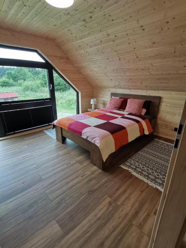 a bedroom with a bed and a large window at Hortensja 2 in Rusinowo
