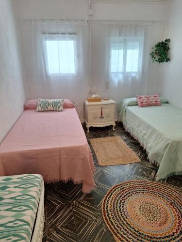 a room with three beds and two rugs at Casa Maibeca in Bolbaite