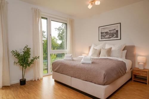 a white bedroom with a large bed and a window at Wohnkultur - Ferienhaus für 10 auf 140qm mit Garten in Wiesloch