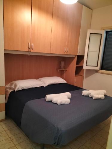 two towels are sitting on a bed in a room at Flore's House Ostuni in Villanova di Ostuni
