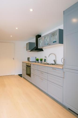 a kitchen with blue and white cabinets and a sink at Apartment with bedroom in Sandnes Sentrum in Sandnes