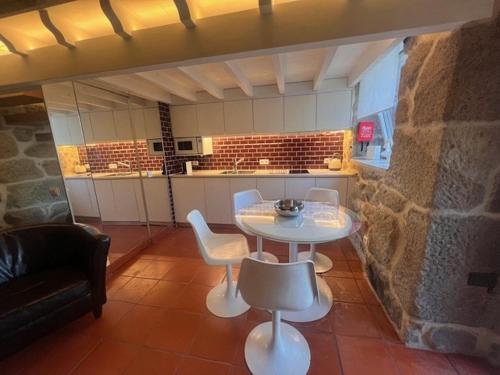 a kitchen with a table and chairs in a room at Casa do Lagar in Fataunços