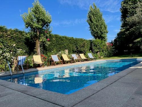 a group of lawn chairs and a swimming pool at Casa do Lagar in Fataunços