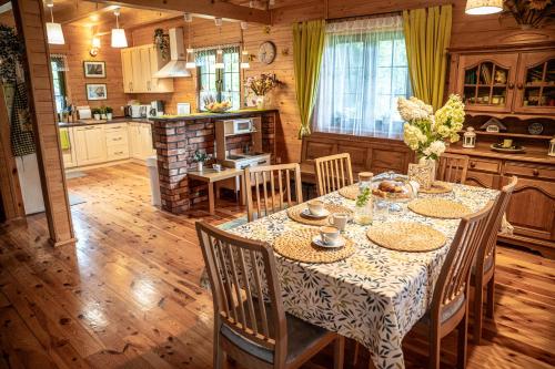 a kitchen and dining room with a table and chairs at Dom Marzeń z jacuzzi pod gwiazdami in Kopalino