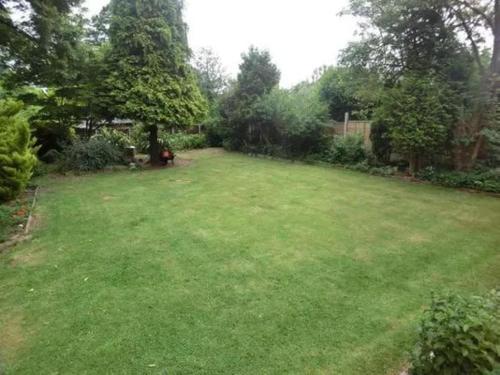 a yard with a large green yard with trees at Bridgerton House - Detached 5-bedroom Property in Gravesend