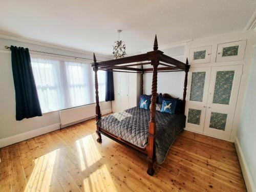 a bedroom with a canopy bed in a room at Bridgerton House - Detached 5-bedroom Property in Gravesend