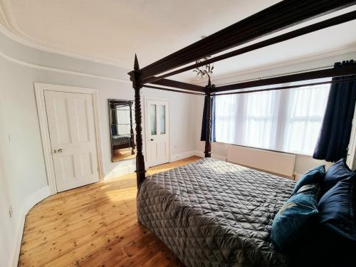 a bedroom with a bed and a large window at Bridgerton House - Detached 5-bedroom Property in Gravesend