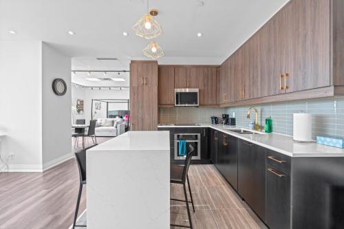 a kitchen with wooden cabinets and a white counter top at Bright Suites Finch West steps to Metro in Toronto