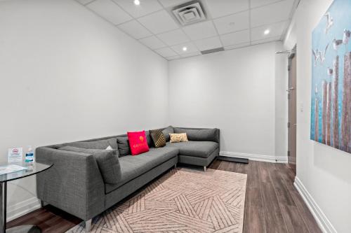 a living room with a couch and a table at Bright Suites Finch West steps to Metro in Toronto