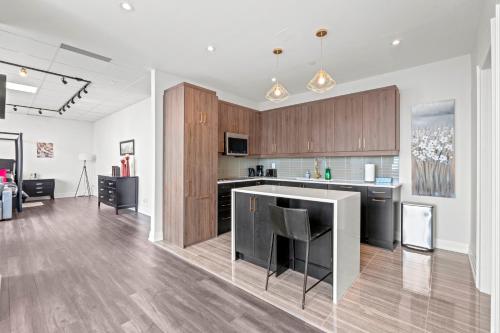 an open kitchen and living room with wooden cabinets at Bright Suites Finch West steps to Metro in Toronto