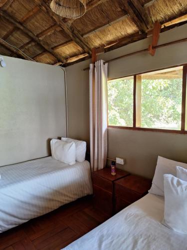 a bedroom with two beds and a window at Mwamfushi Safari Lodge in Mulola