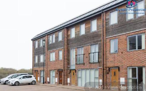 a brick building with cars parked in front of it at Syster Properties Stunning Apartment for Contractors and families in Leicester