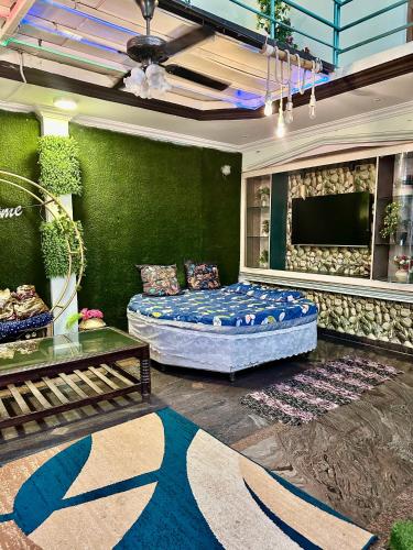 a living room with a bed and a flat screen tv at Green Mysore 2BHK Apartment 1km from railway station in Mysore