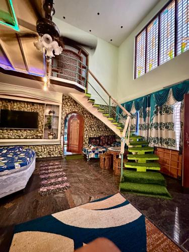 a living room with a staircase and green carpet at Green Mysore 2BHK Apartment 1km from railway station in Mysore