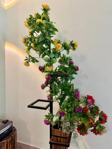 a bunch of flowers in a pot on a shelf at Green Mysore 2BHK Apartment 1km from railway station in Mysore