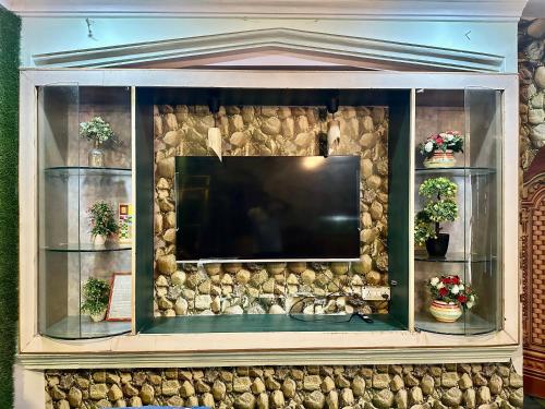 a large entertainment center with a flat screen tv at Green Mysore 2BHK Apartment 1km from railway station in Mysore