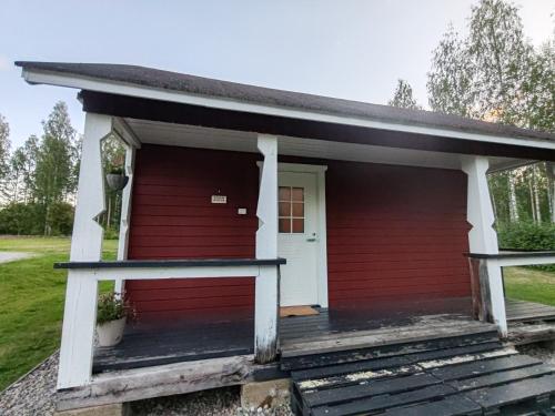 a red house with a white door and a porch at Dream house in Savonlinna