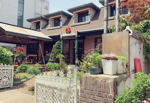 a house with a white fence and some plants at Cozy Erin Stay, Seoul in Seoul