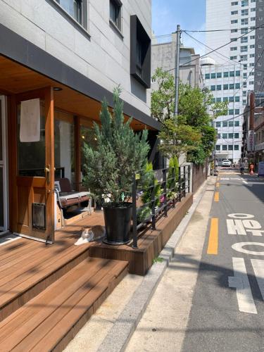 a cat laying on a wooden deck outside a building at Cozy Erin Stay, Seoul in Seoul