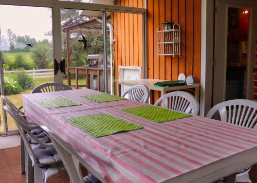 une table de salle à manger avec une nappe rose et verte dans l'établissement Cottage on the Pond, à Millbrook