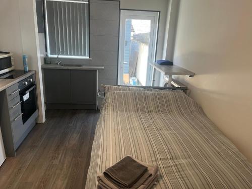 a small room with a bed and a kitchen at Townsend lane accommodation in Liverpool