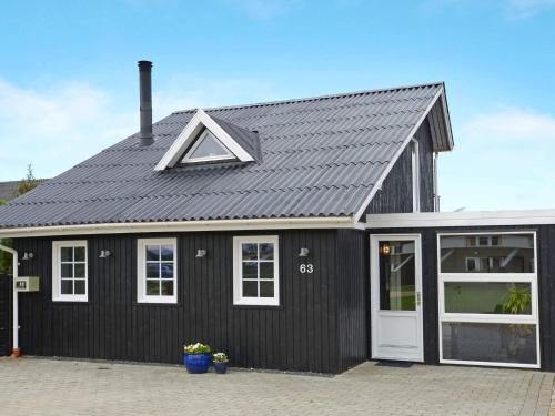 ein schwarzes Haus mit einem grauen Dach in der Unterkunft Fjord View Retreat - By Traum Ferienwohnungen in Falen