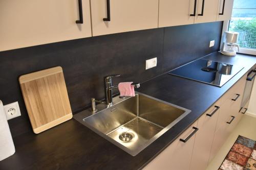 a kitchen with a sink and a black counter top at Gästehaus in Thüringen in Thüringen